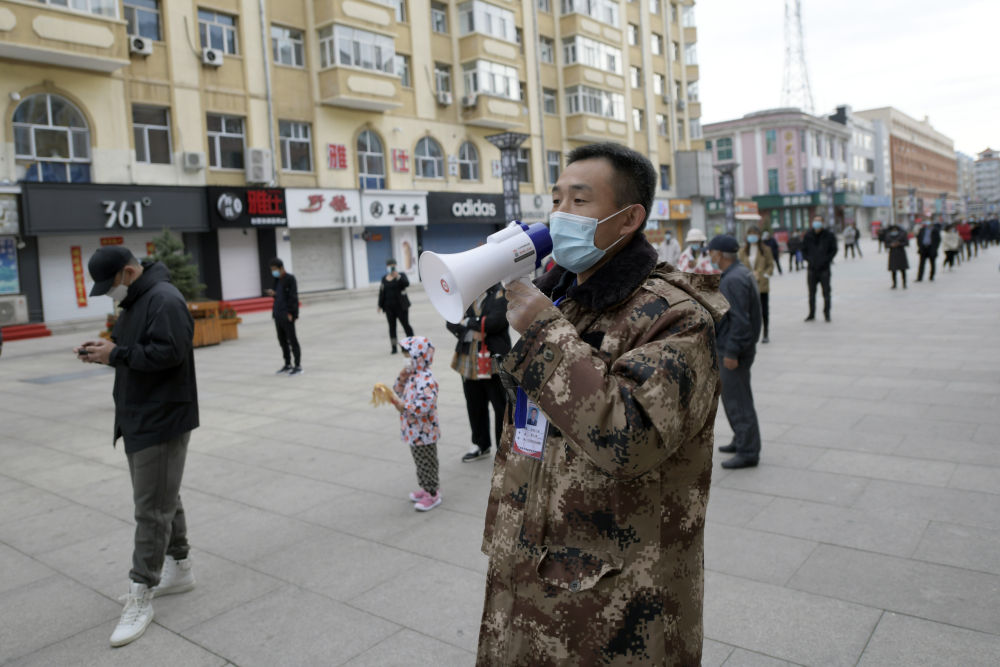 9月25日,在哈尔滨市巴彦县一核酸检测点,工作人员在现场维持秩序